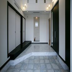 松阪の家：「大理石調タイル・白」と「建具・座和入口式台・黒」のモダン空間とメリハリを演出