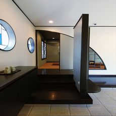 平沼の家：玄関土間から衝立壁のバックヤードに収納を配し、雑になりがちな玄関空間を穏やかに仕切り玄関横の座の空間に誘う