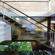 平沼の家：とんぼの階段手摺壁は透明強化ガラスと「飛散防止フィルム貼」（３M製品）・階段下は床埋込グリーンオブジェで演出