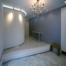 慈しむLegameな佇まい：コーブ照明・玄関ホール階段室Ｒ型と玄関シャンデリア（ヤマギワ仕入）・nikeデザイン
