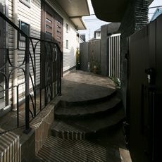 あきづの邸宅：優しく丸みを持たせたアプローチ階段・諏訪鉄平石：鍛鉄の古代銀杏紋様のオリジナルフェンス・nikeデザイン・TOPU製作