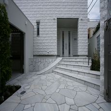 nikeデザインポイント：慈しむLegame：白乱石（タソスホワイト）のＲ型アプローチと階段〔whiteを際立てる〕